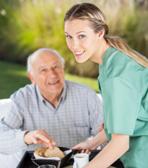 caregiver giving food to a senior